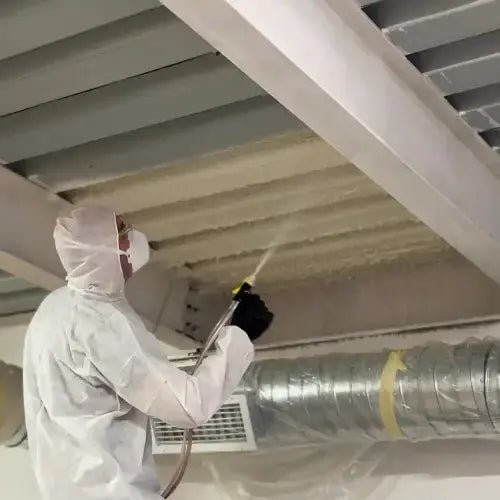 video of worker in a protective suit and mask applying Honeyfoam spray foam insulation