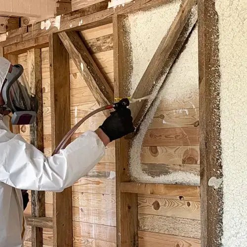 video of worker in a protective suit and mask applying Honeyfoam spray foam insulation