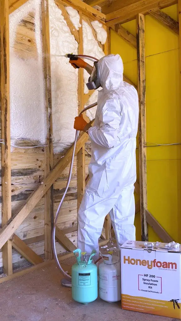 man in gear spraying open cell foam