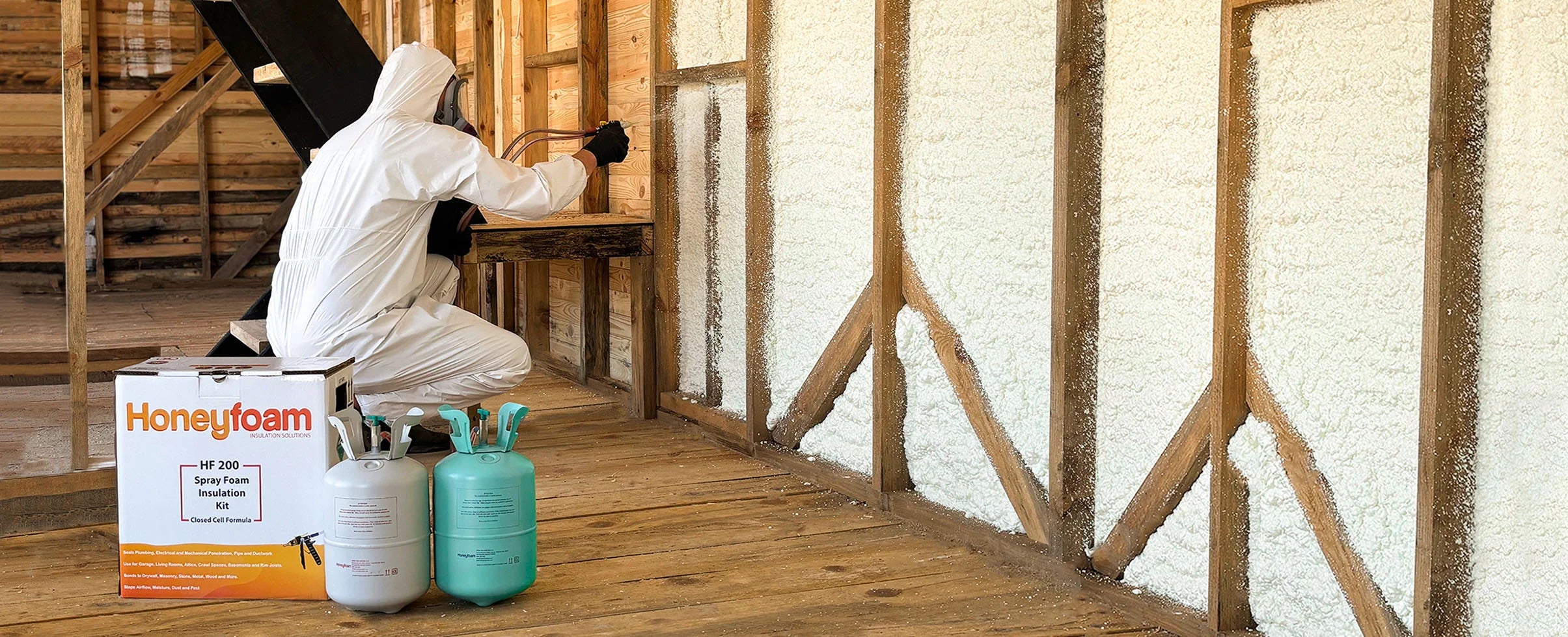 Person in protective gear applying foam insulation to a wall with Honeycomb Foam packaging visible.